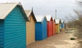 Views of rows of colourful beach bright painted summer holiday bathing box`s along a sandy beach on a sunny day, Brighton beach,