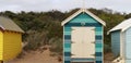 views of rows of colourful beach bright painted summer holiday bathing box\'s along a sandy beach on a sunny day, Brighton beach,