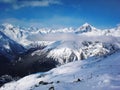 Views of snow capped mountains of Dombay. Winter Sunny day, mountain range, clouds Royalty Free Stock Photo