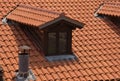 Views of some red tile roofs with a chimney and a glass attic