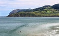 Views of Urdaibai biosphere reserve with mountains, blue sky and white clouds in the Basque Country. Surfers are waiting the best