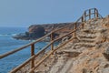 Wooden staircase of a lookout with a boat sailing in the sea in Ajuy, Fuerteventura