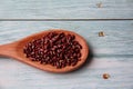 Vigna angularis, in a wooden spoon, isolated, on wooden table.