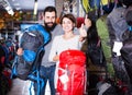 Vigorous couple examining rucksacks in sports equipment store