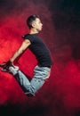 Vigorous dancer man in the air isolated over smoky space