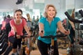 Vigorous females of different age training on exercise bikes Royalty Free Stock Photo