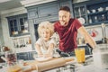 Vigorous nice boy and man adding ingredients