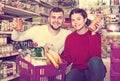 Vigorous young family choosing purchasing canned food for week a Royalty Free Stock Photo