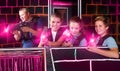 Vigorous young parents and children with laser pistols playing l