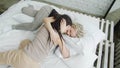 Vigorous young woman jumps in bed where her girlfriend is waiting to hug