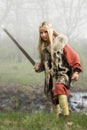 Viking girl with sword in a fog wood Royalty Free Stock Photo
