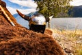 Viking helmet and weapons on fjord shore, Norway Royalty Free Stock Photo