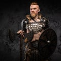 Viking posing with shield and axe against dark background Royalty Free Stock Photo