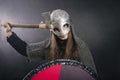 Viking stands with an ax on a gray background. A man in chain mail and a helmet waves his weapon. A medieval warrior in armor goes