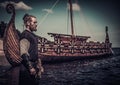 Viking warrior standing near Drakkar on seashore Royalty Free Stock Photo