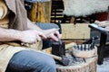 Viking week in York, 2019. Man is making metal bracelet using little hummer