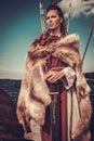 Viking woman with sword and shield standing on Drakkar.