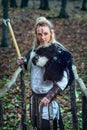 Viking woman warrior fur collar and specific makeup rising ax above head, ready to attack