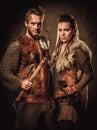 Vikings couple posing in studio on dark background.