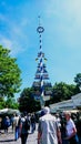 Maypole under sunlight and blue sky in Viktualienmarkt, a local market with tourists walking around and surrounded by