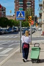 Viladecans - May 20, 2023: Lonely unrecognizable woman with her empty shopping cart in the street