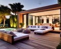 Villa backyard terrace in the evening with couches and lounge chairs with pool . Suburban house. Vacation and wellness spa resort Royalty Free Stock Photo