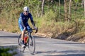 A solitary man rides his bike on a road Royalty Free Stock Photo