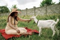 Village animals. Happy pregnant woman hugs goat, concept of unity of nature and man. Life in the countryside. Royalty Free Stock Photo