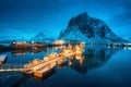 Village with boats on the sea at night and snowy mountains Royalty Free Stock Photo