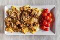 Village breakfast - fried potatoes and mushrooms with tomatoes on white plate Royalty Free Stock Photo