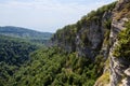 Village in caucasus mountains and cliff covered with pine trees Royalty Free Stock Photo