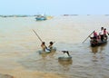 village children from a Cambodian fishing village, swim in metal basins on Tonle Sap Lake -Siem Reap, Cambodia 02/21/2011