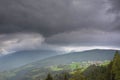 Scenic aerial view on villages in Dolomites with mountains in clouds on background and meadows on foreground Royalty Free Stock Photo