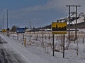 Village entrance of small town Kirkjubaejarklaustur in southern Iceland on sunny winter day with yellow-colored place-name sign.