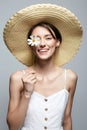 village girl in hat with flower. beautiful smiling young woman with chamomile Royalty Free Stock Photo