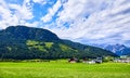 Village among green meadows and Austrian Alps Royalty Free Stock Photo