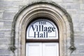 Village hall sign above building entrance door