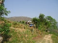 Village house made of clay and stone with narrow road and hills back Royalty Free Stock Photo