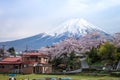 Village houses with sakura cherry blossom trees on moutain Fuji background, Yamanashi, Japan, a beautiful view of Fuji in the back