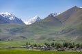 The village of Kyzyl Tuu with the Tian Shan Mountains in the background in Kyrgyzstan Royalty Free Stock Photo