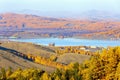 The village of Mindyak on the shore of the lake among the Ural Ridges of Miguele in late autumn in the rays