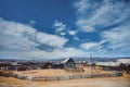 a small village under a blue sky, with snow-capped mountains in the background. Old houses. Russia, Siberia, Arshan