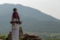 Village Old Man Holding Granddaughter in Shoulder, Greenish Background