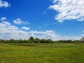Village panorama spring - spacious green meadow, blue sky with c Royalty Free Stock Photo