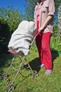 Village poor woman collect old rubbish metal and plastic  and are taken out on a wheelbarrow Royalty Free Stock Photo