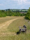 Village of Sandridge on the horizon, photographed with a wooden bench in the foreground from Heartwood Forest, near St Albans, Her