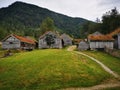 Village with small wooden houses and a pathway in front of a green hill Royalty Free Stock Photo