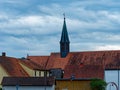 Village with stork high up on cross of church spire by a cloudy blue sky Royalty Free Stock Photo