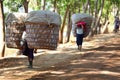 Village women carrying large baskets of produce in