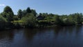 Village with wooden house built on the shore of a pond. Shot. Ecological place for living, small house, green trees and Royalty Free Stock Photo